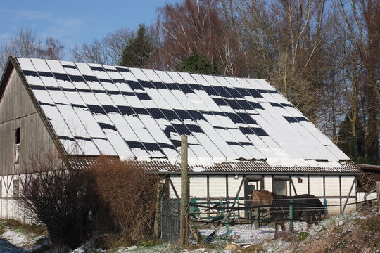 Ineffizienz einer schneebedeckten Photovoltaikanlage bei blauem Himmel