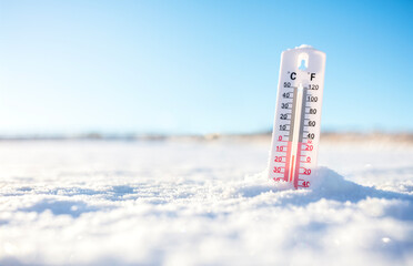 Thermometer in the winter snow showing sub zero minus temperature