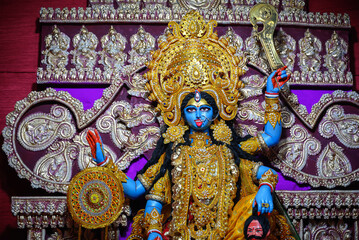 Idol of Goddess Maa Kali at a decorated puja pandal in West Bengal, India. Kali puja is a famous...
