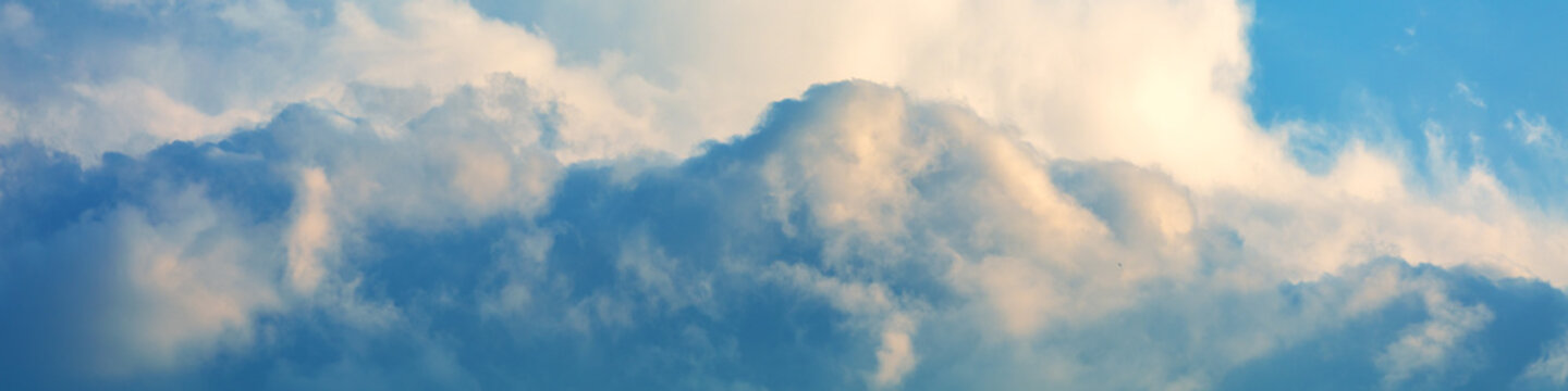 Blue cloudy sky on a sunny day. Sky texture. Abstract nature background. Horizontal banner