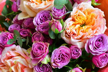 Bouquet of orange peony and small purple roses. Beauty in nature, a spring bouquet. Floral natural background. Flowering and fragrance 