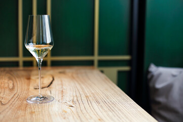 Transparent drink in glass goblet on wood background