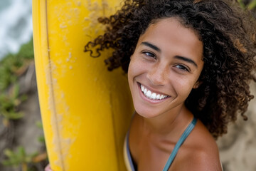 Biracial woman smiling holding surfboard, energetic and bold.