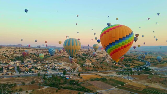 Aerial video. Captured against the canvas of the Cappadocian sky, this video showcases the enchanting spectacle of a hot air balloon festival. The vibrant balloons rise gracefully over the valleys of