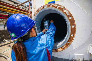 Worker female hand holding gas detector inspection safety gas testing at front manhole tank chemical to work inside confined space - obrazy, fototapety, plakaty