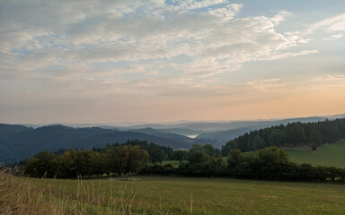 Obraz premium Wooded hilly landscape in the Czech Republic with Milada lookout tower above the Vltava River meander.