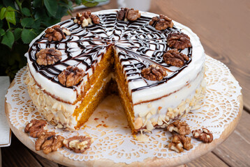 A  delectable carrot cake with creamy topping, presented on a white background.
