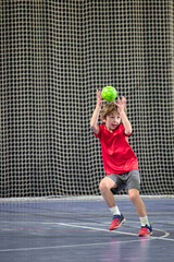 Détermination juvénile, enfant de huit ans gardien débutant arrêtant le ballon au handball