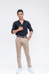 Young Filipino man posing with a confident smile, dressed in stylish casual black shirt and khaki...