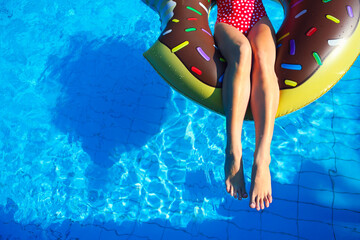 Young woman on inflatable mattress in the swimming pool