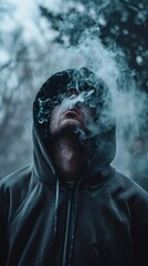 a man in a hoodie smoking cigarette