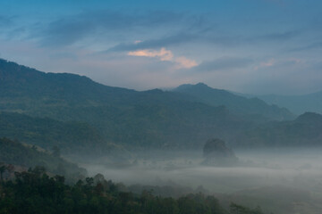 Landscape morning fog in mountain viewpoint of Khao Chang Noi Phu Langka Phayao Province of Thailand. Hills are lined with beautiful green fields and forests. Under sky is gloomy in the morning. - Powered by Adobe