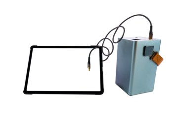 Tablet PC with a blank transparent screen next to a large power bank (charging station) with a USB cable on a transparent background. Mobile power supply