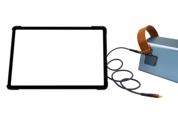 Tablet PC with a blank transparent screen next to a large power bank (charging station) with a USB cable on a transparent background. Mobile power supply