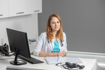 Portrait of young female medicine doctor sitting and working at her office. Healthcare and medical...