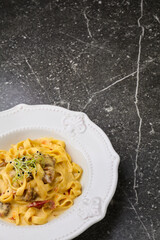 Cajun chicken Fettuccine pasta in a creamy sauce on white plate. Top view. Copy space