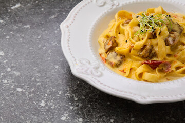 Cajun chicken Fettuccine pasta in a creamy sauce on white plate. Copy space