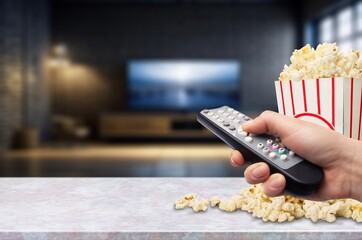 Tasty popcorn and tv remote control at home.