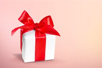 A red beautiful gift box with a ribbon on desk