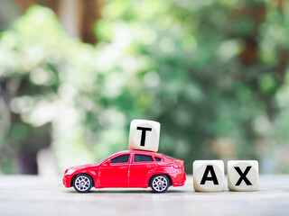 Toy car and Wooden blocks with the word TAX . The concept for paying TAX for car in future