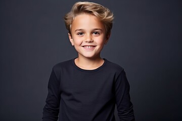 Portrait of a smiling little boy on a dark background. Kid's fashion.