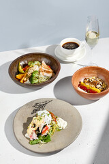 A sumptuous breakfast with homemade yogurt, chicken and avocado bowl, crab with poached egg, coffee, and sparkling wine