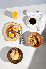 Top view of a breakfast spread with potato pancakes, roast beef, and eggs, complemented by coffee and orange juice