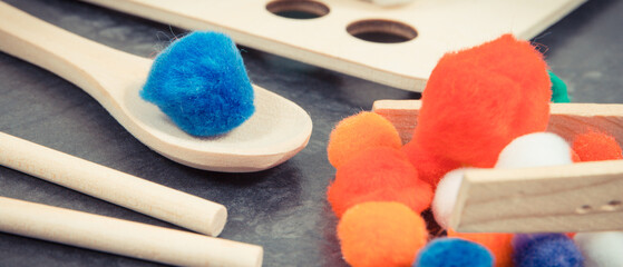 Colorful pompoms as accessories using for playing and development of kids motor skills, coordination and logical thinking