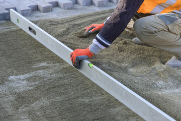 Before laying decorative stone on walkway, sand must be leveled