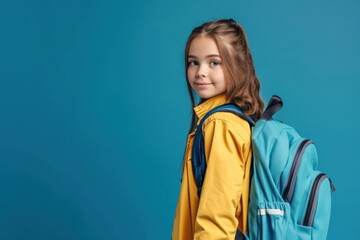 Schoolgirl with backpack isolated on solid color studio background