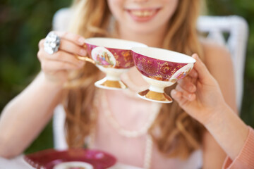 Hands, tea cup and cheers, party and girl children playing with care, celebration and fun in backyard. Closeup of toast, beverage or drink with friends outdoor in garden for game or birthday