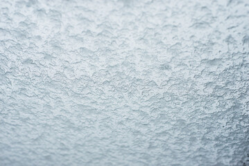Closeup of snow flakes on window on grey sky background