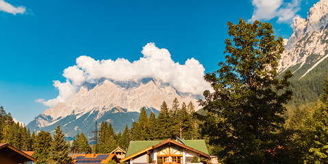 Alpine summer view with Mount Zugspitze wearing a crown of clouds at Tiroler Zugspitzarena,...