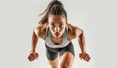 Foto op Plexiglas Confident female athlete ready for running pose on white background. © radekcho