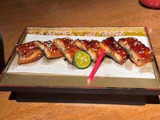 Close up cut grilled Japanese eel or unagi kabayaki with sesame on a plate. Japanese food style.