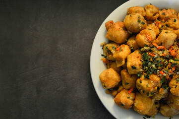 Tahu cabe garam, made from white tofu which is covered in flour and then fried and sautéed with chopped chilies, spring onions and chopped garlic. vegetarian healthy food.