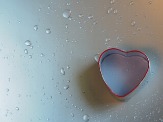 Heart shaped box on silver background with water drops for Valentine's Day