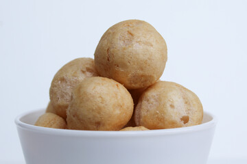 Fish crackers in ball shape, on a white bowl. isolated on white background