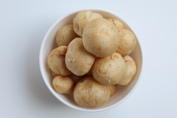 Fish crackers in ball shape, on a white bowl. isolated on white background, flat lay or top view