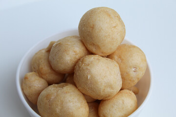 Fish crackers in ball shape, on a white bowl. isolated on white background