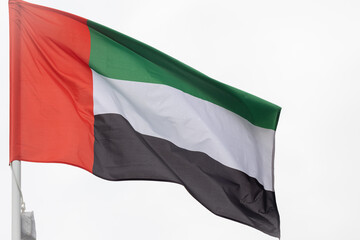 Obraz premium Flag of the United Arab Emirates. A large National UAE flag flutters in the wind. Close-up. Great for news. United Arab Emirates flag on white background