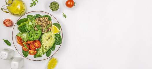 healthy vegan lunch bowl with broccoli, avocado, quinoa and tomatoes on a white background. Long banner format. top view