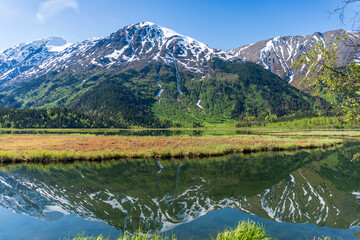 Tern Lake along Seward Highway on Kenai Peninsula in Alaska. At junction with Sterling Highway in Chugach National Forest. Mountain landscape perfectly reflected in mirror still alpine lake.
