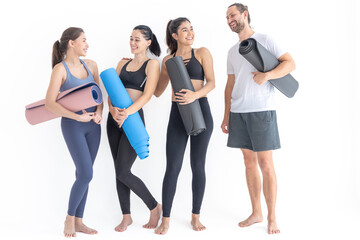 Fototapeta na wymiar Group of happy sporty women and guy wearing body stylish sportswear holding personal carpets leaned on a white background. waiting for yoga class or body weight class. healthy lifestyle and wellness