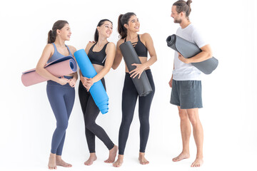 Obraz na płótnie Canvas Group of happy sporty women and guy wearing body stylish sportswear holding personal carpets leaned on a white background. waiting for yoga class or body weight class. healthy lifestyle and wellness