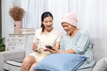 family concept Daughter taking care of elderly mother at home The couple happily smiles and uses...