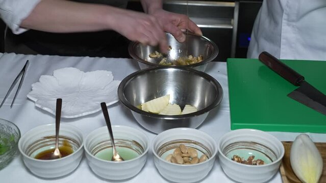 Las manos de dos cocineros preparando una receta.