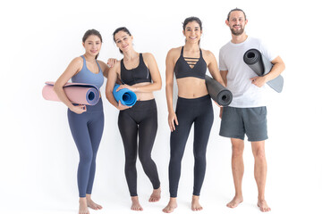 Group of happy sporty women and guy wearing body stylish sportswear holding personal carpets leaned on a white background. waiting for yoga class or body weight class. healthy lifestyle and wellness