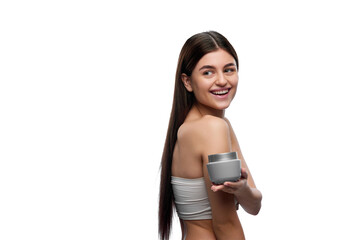 Young beautiful lady presenting jar of skin care cosmetic product and looking over shoulder against white background. Concept of organic beauty cosmetic, spa procedures, body care.