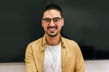 Obraz premium Portrait of a smiling male coach presenting to an audience in the lecture hall.